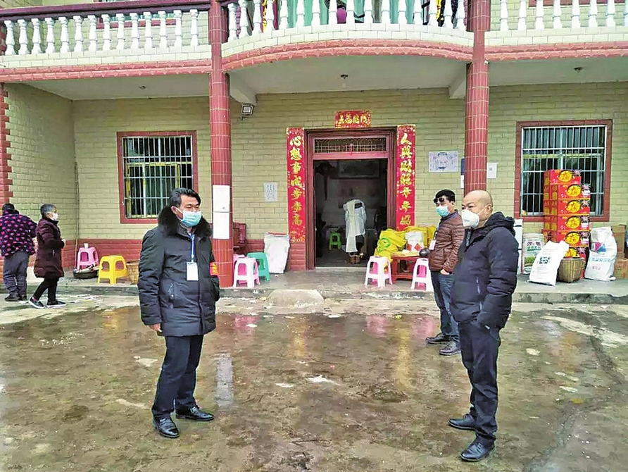薛常荣(左一)为村民宣传防疫知识