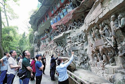 游客在大足石刻宝顶山景区参观