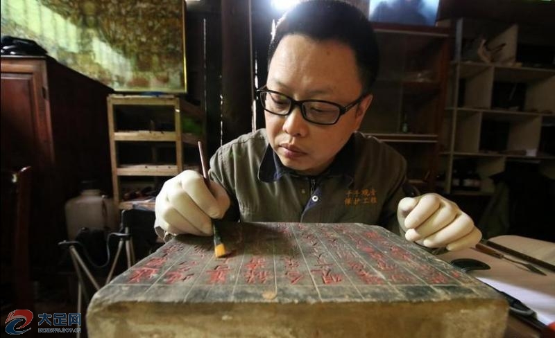 图为工作人员正在清理石碑文字.记者 罗国家 摄